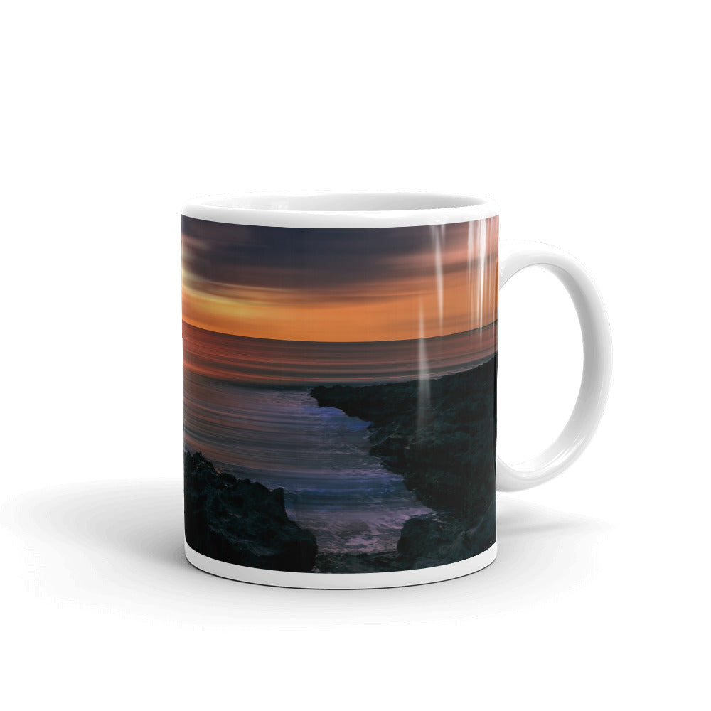 Weiß glänzende Tasse/Sonnenuntergang vor der felsigen Küste